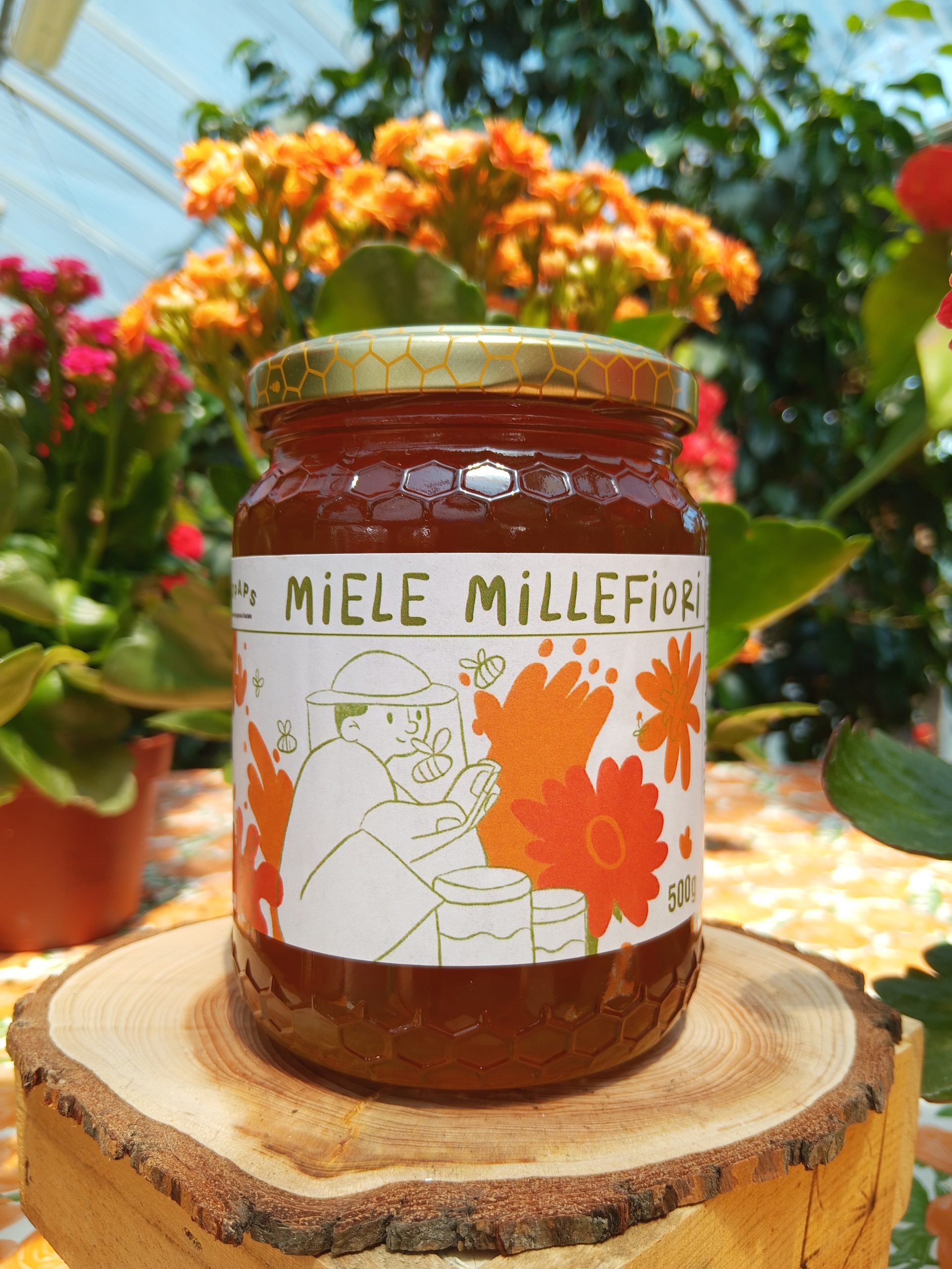 Vasetto di miele con etichetta nei toni dell'arancione per indicare il miele millefiori